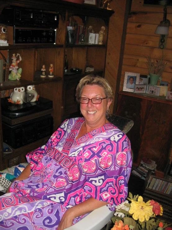 an older woman in a brightly colored robe sitting in a chair