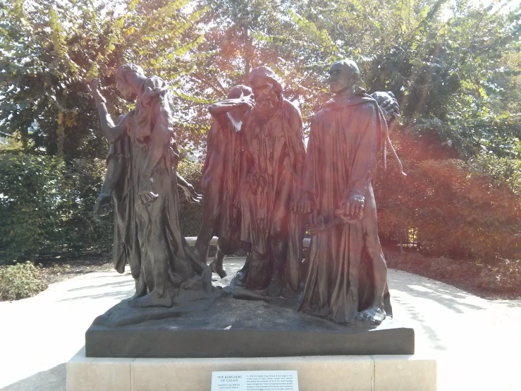 a statue of three women and a dog standing by each other