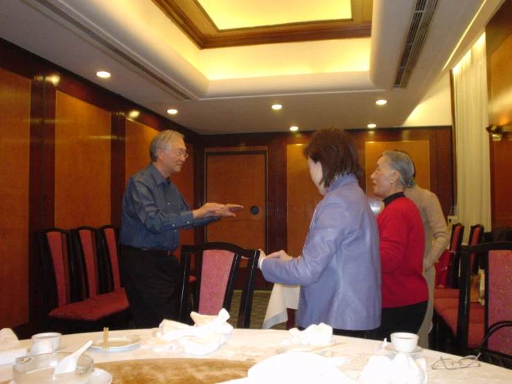 two women and one man talking at a restaurant