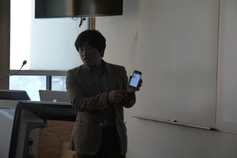 a man holding a smart phone standing in a room