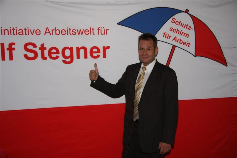 man posing with a large umbrella at an event