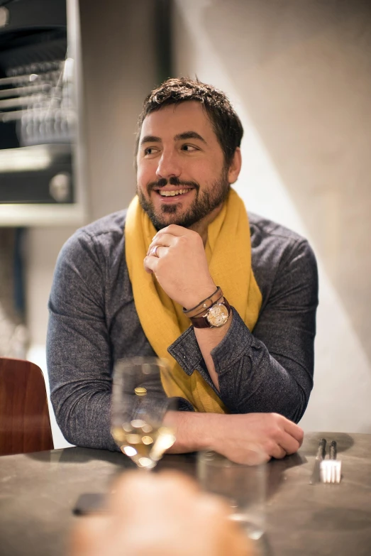 a man sitting at a table posing for a po