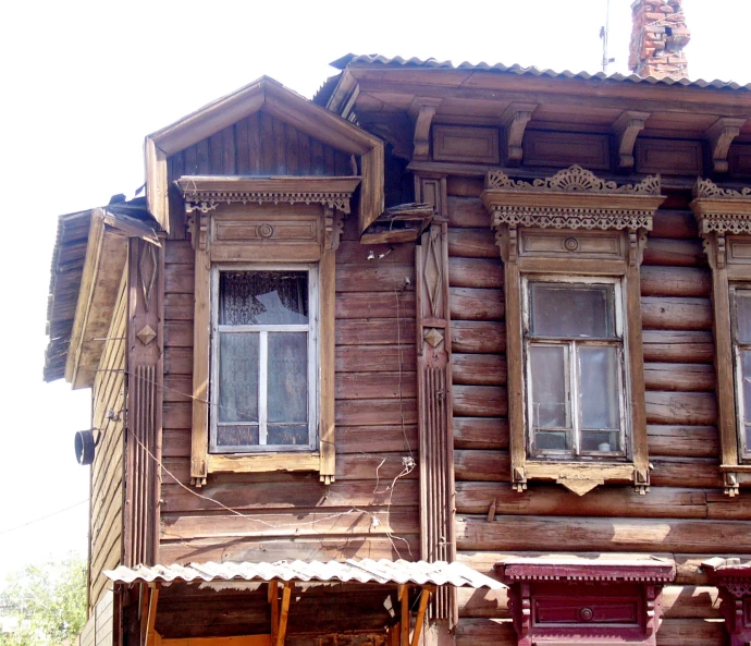 wooden house with ornate carvings and open windows