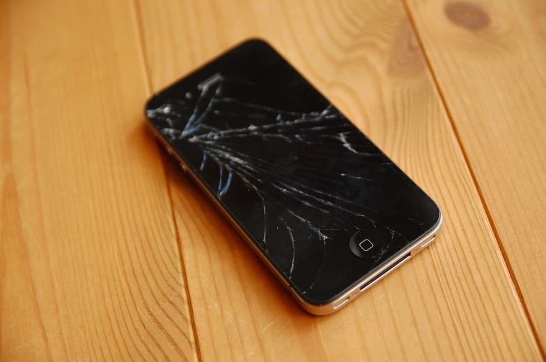 the cellphone has been broken on the wooden floor