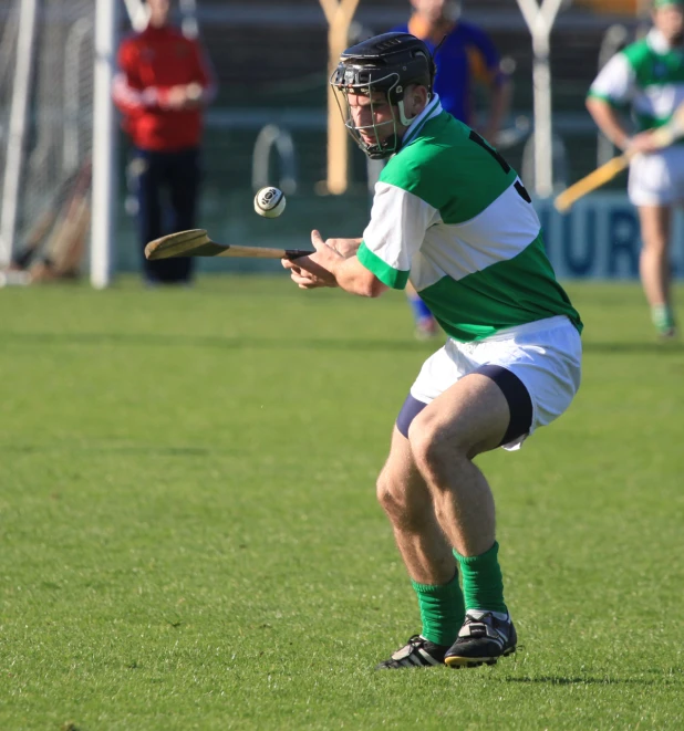 a man with green and white jersey throwing a ball