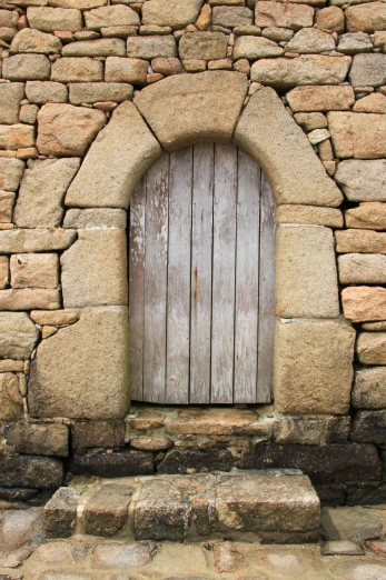 an old door is set into some very small rocks