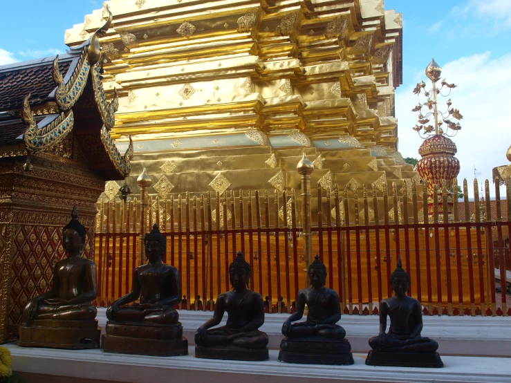 statues are shown in front of a golden building