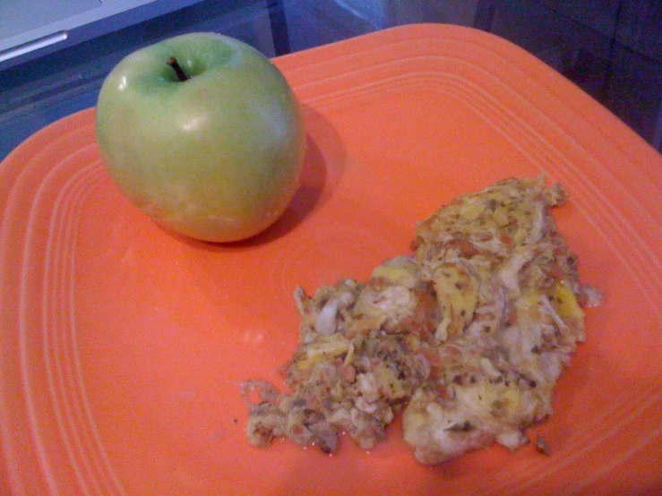 a slice of hash browns next to an apple