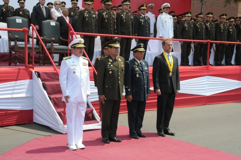 four uniformed men standing on a red carpet