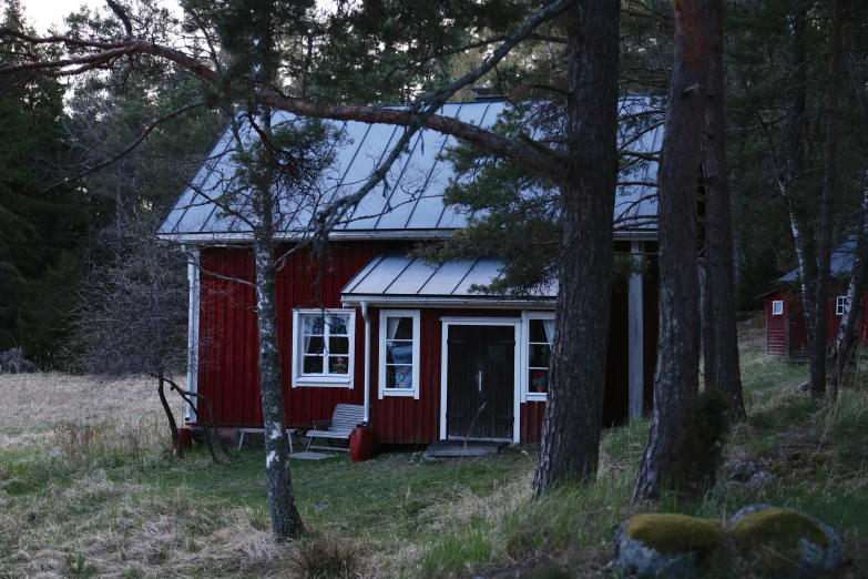 a barn that is sitting in the grass next to trees