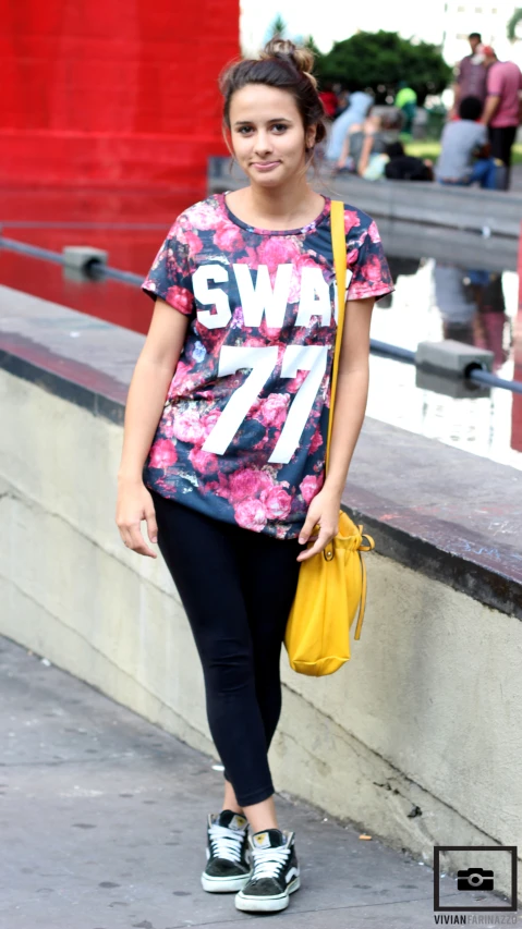 a  is walking down the sidewalk with a yellow purse