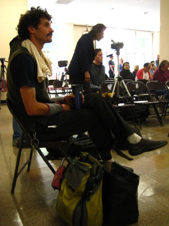 a man sitting in a chair near some other people