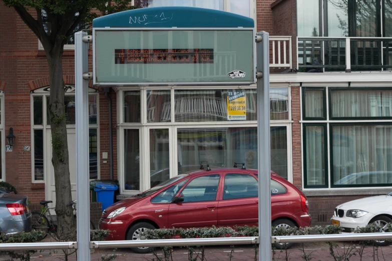 a car parked by some buildings near a fence