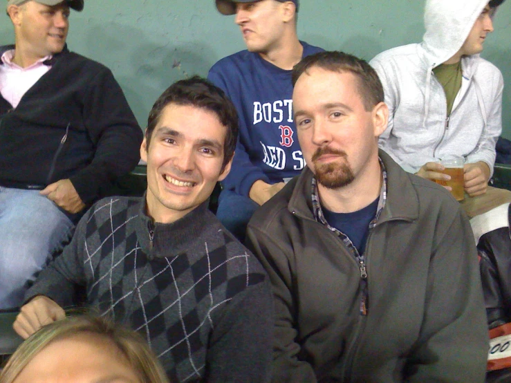 a couple of men sitting next to each other at a baseball game