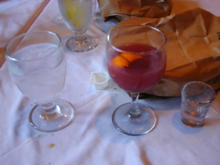 three glasses of alcohol sitting on a table