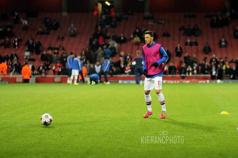 a soccer player in purple and blue poses with a soccer ball