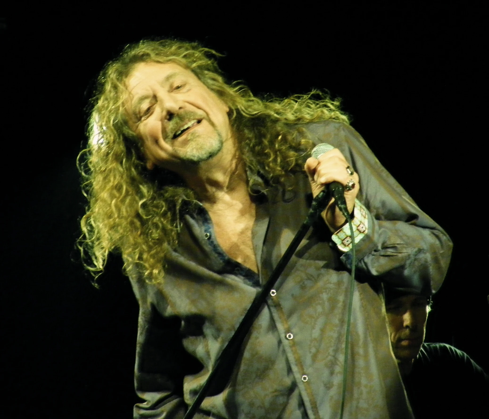 a man holding a microphone with long hair