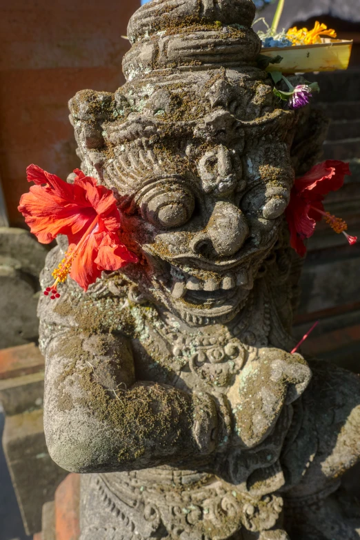 a statue holding a flower in the corner of a room