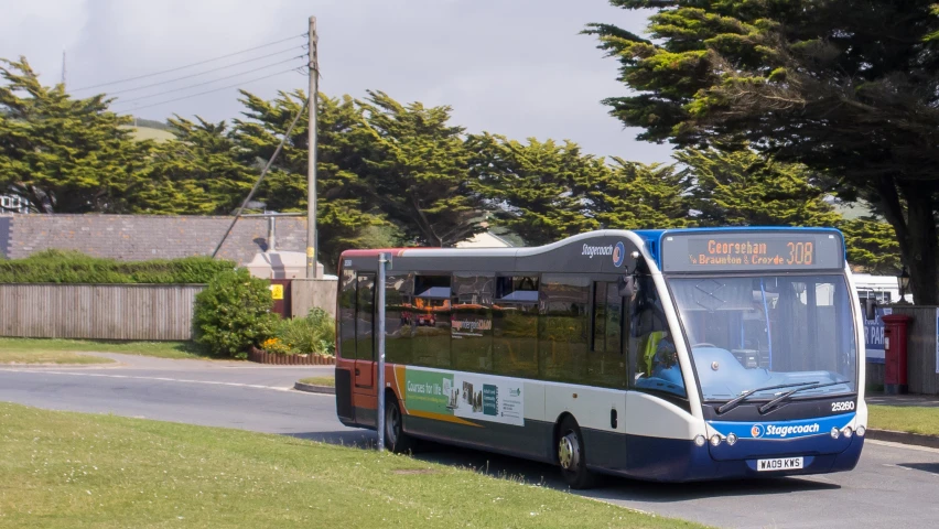 the large commuter bus is driving down the street