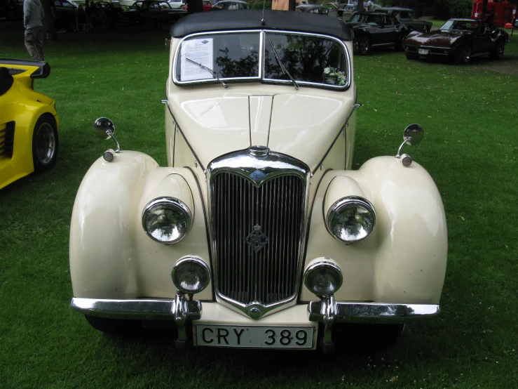 an antique car that is parked in the grass