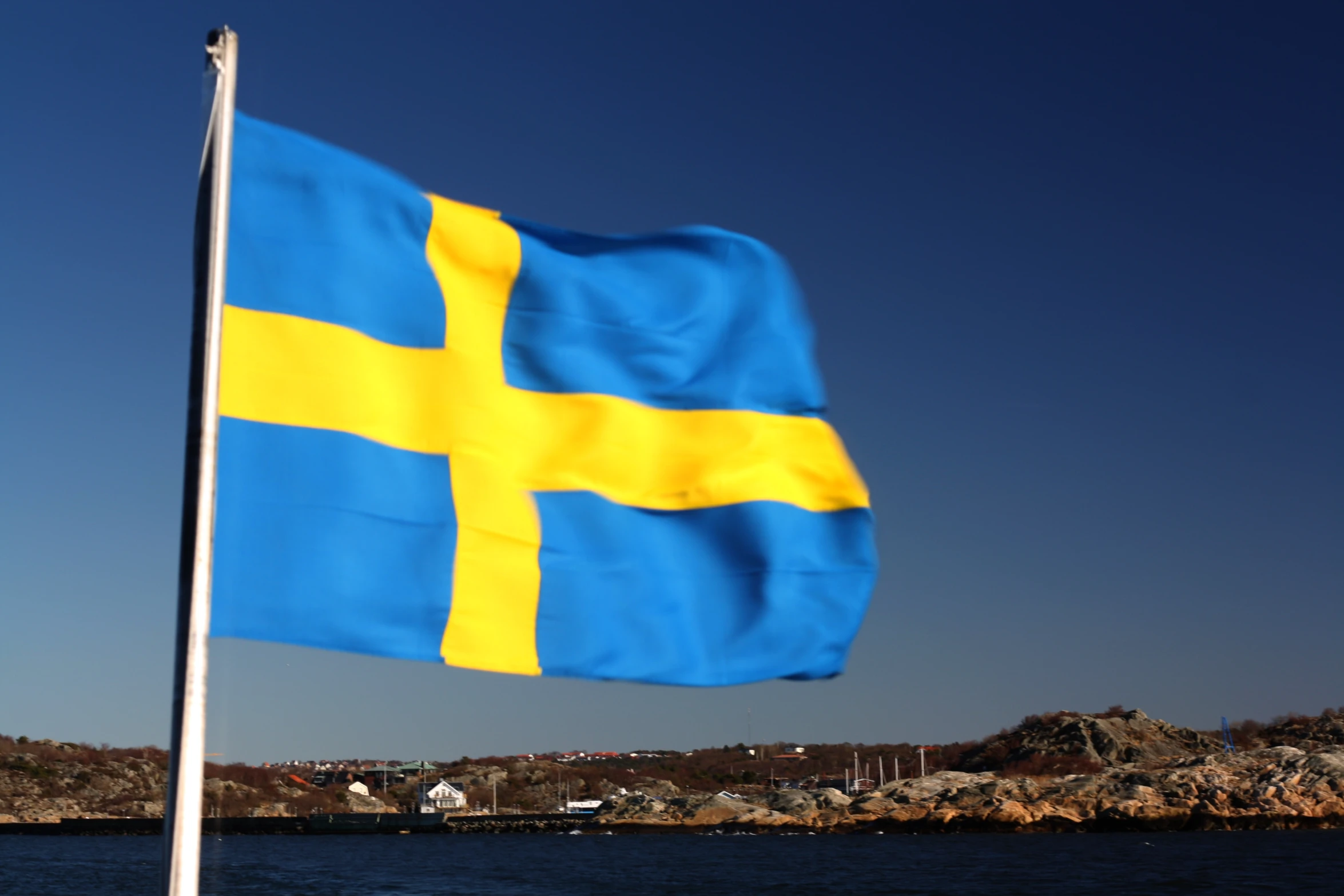 a large flag flying from the side of a body of water