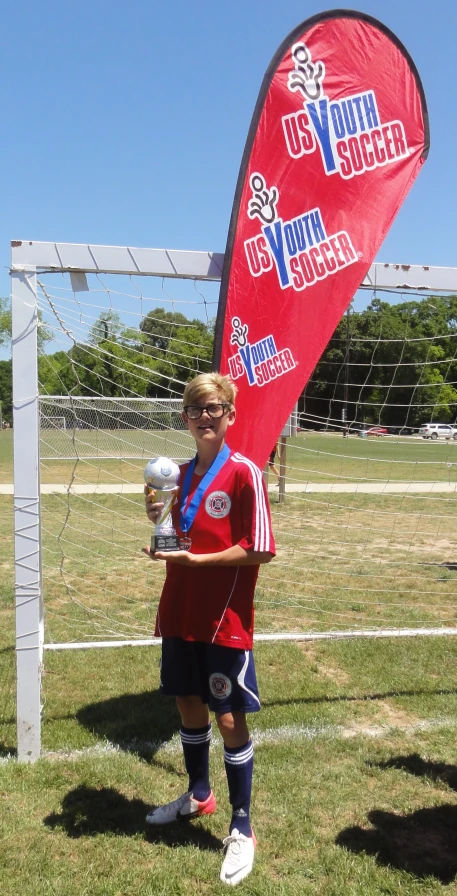 a person posing next to a red flag with their trophy