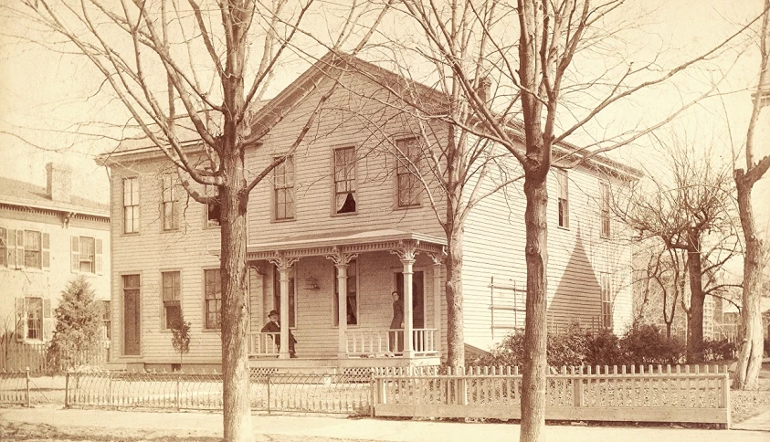 a large white house with a fence in front