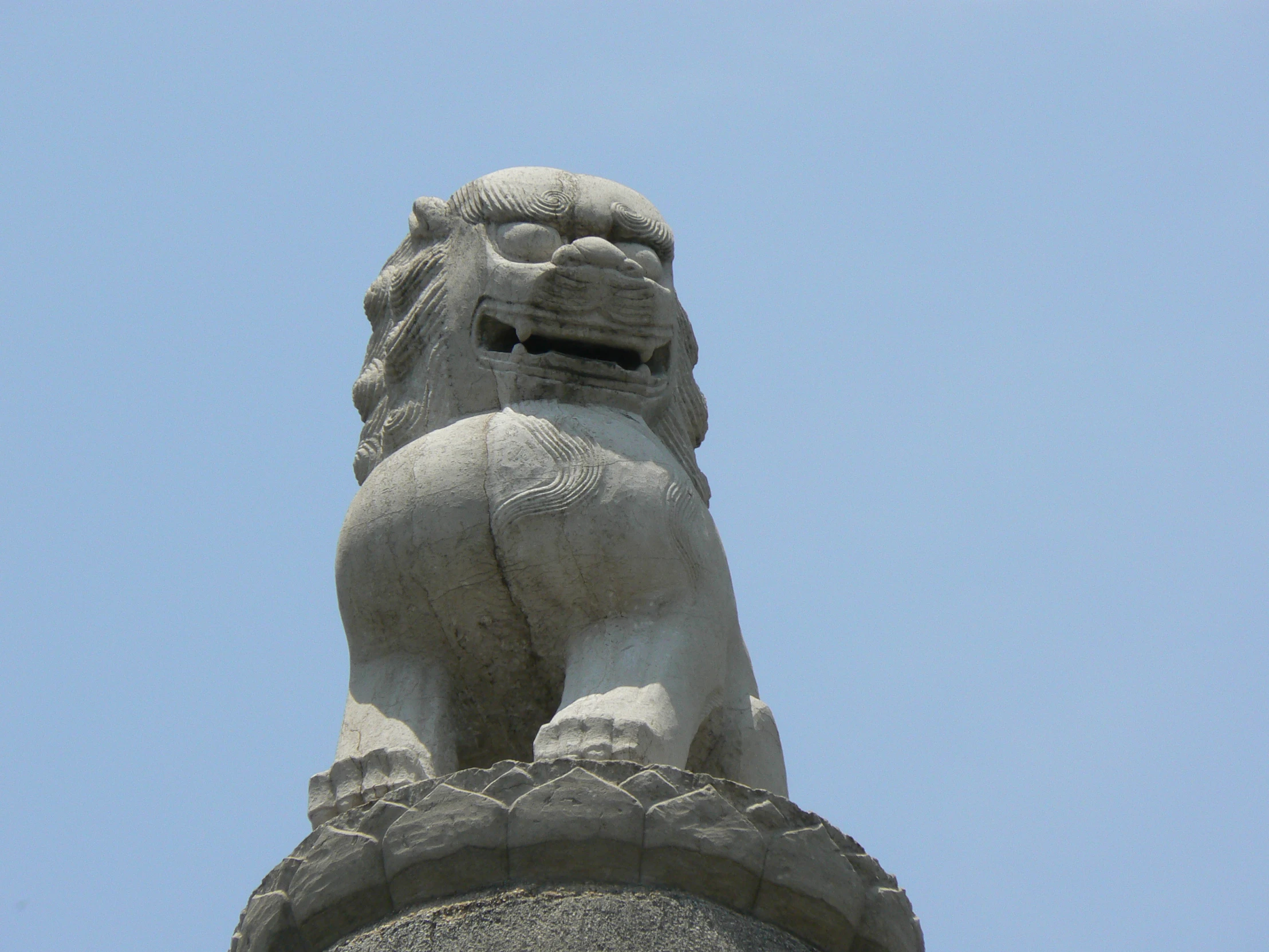 the statue of the stone lion is against the sky