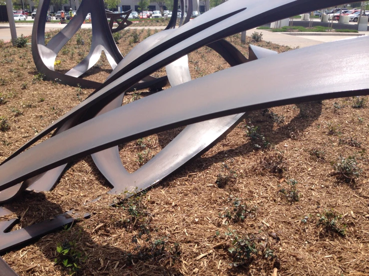 a couple of large silver sculptures on top of grass