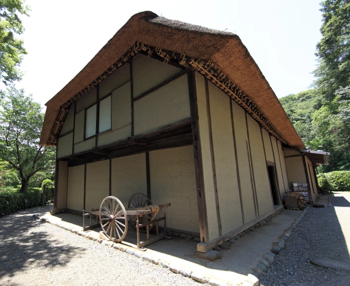 an old house with a wagon and a tree