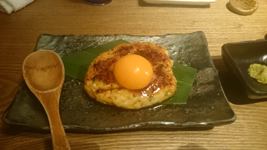 a small piece of food sitting on a plate with a spoon
