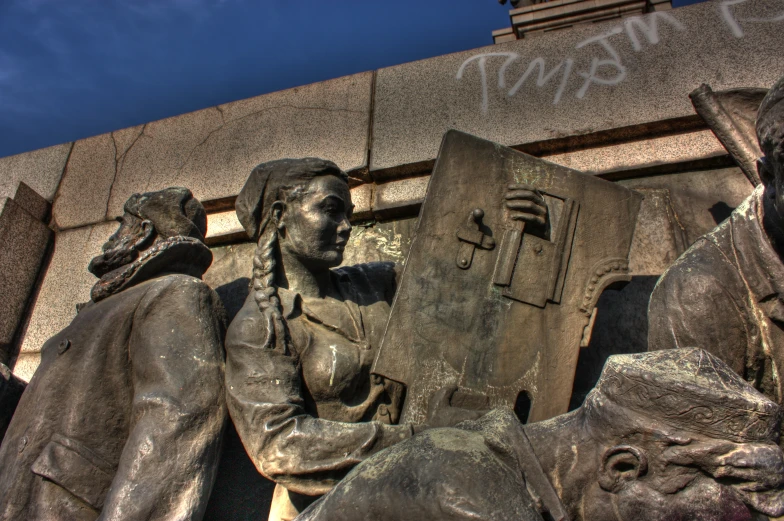 a monument with a man reading a book and another man with a dog