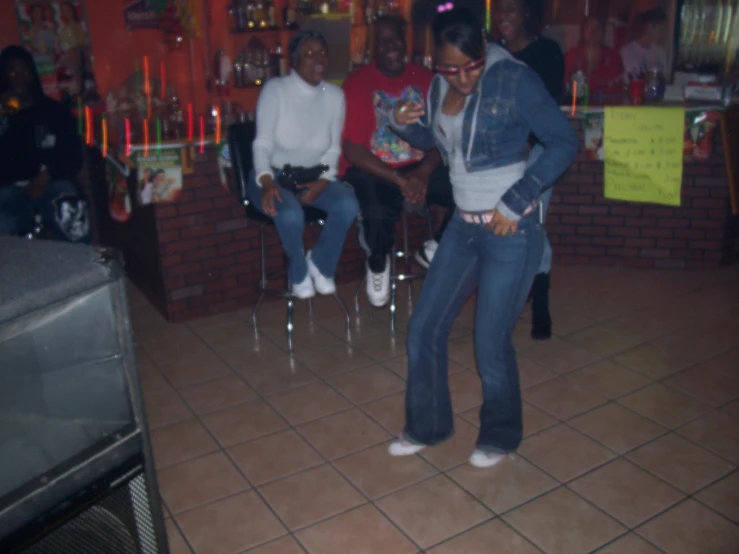 two women and one man watching television in a room with several chairs