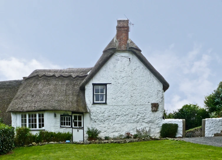an old cottage with a whitewashed exterior