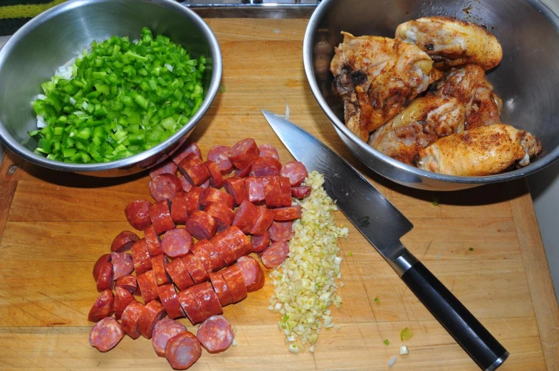 two bowls of chopped up meat, a plate with diced onions and a large bowl of meat