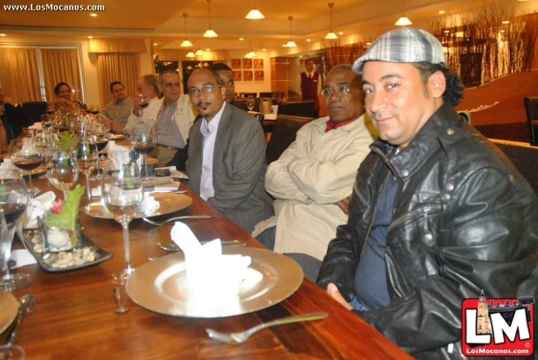 men in black jacket sitting at long table