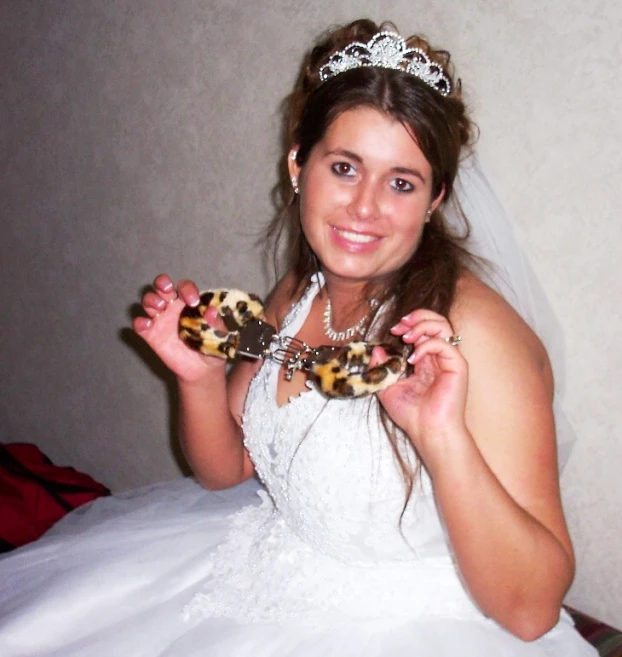 a lady in a wedding dress holding an animal print brooch