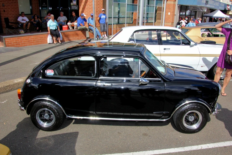 a small car parked next to a large white car