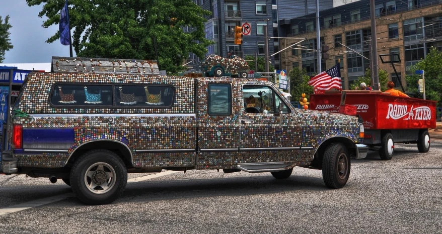 a truck is adorned with soda cans as it passes by in the parade