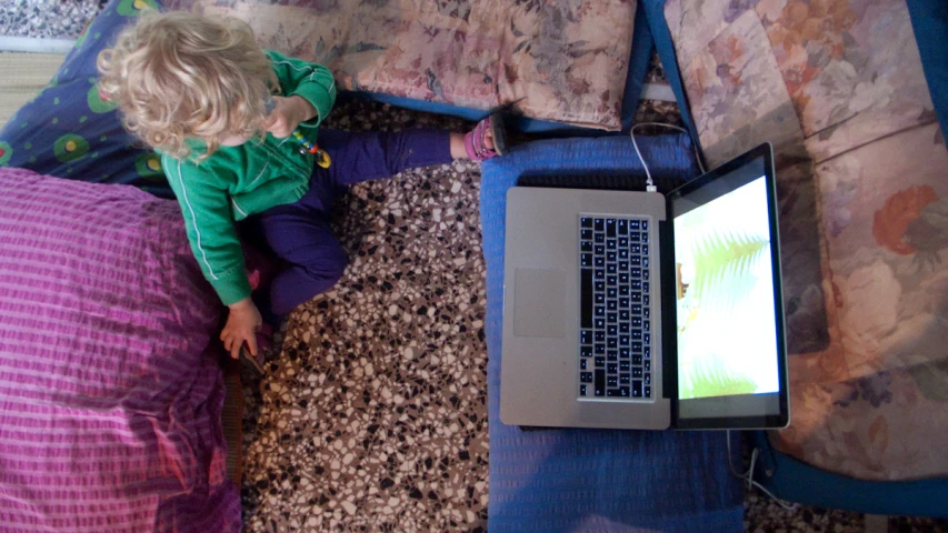 the baby is watching television on her laptop