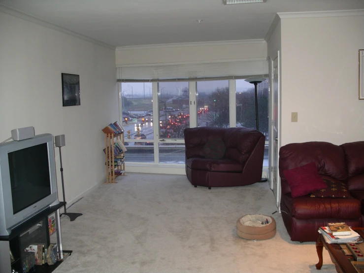 a living room with a brown leather couch and two recliners