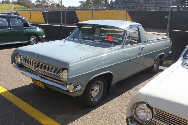 a vintage car is parked beside a newer one in a parking lot