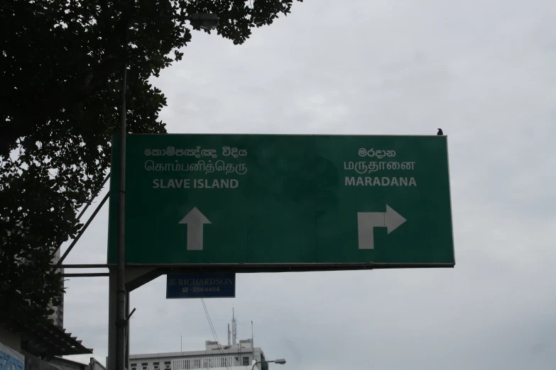 a green and white road sign indicating directions