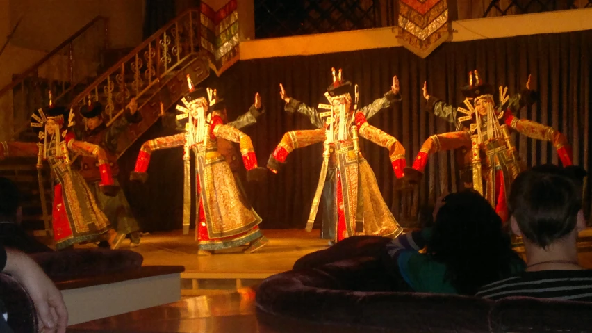 four wooden figures in gold with red and white ribbons