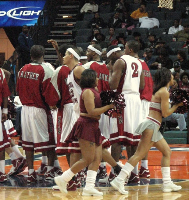 a group of cheerleaders and basketball players walk around the court