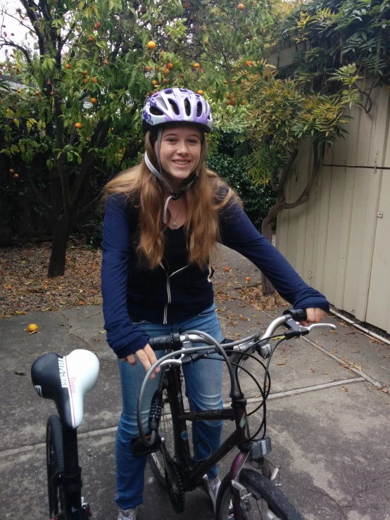 a smiling girl on her bike poses for a po