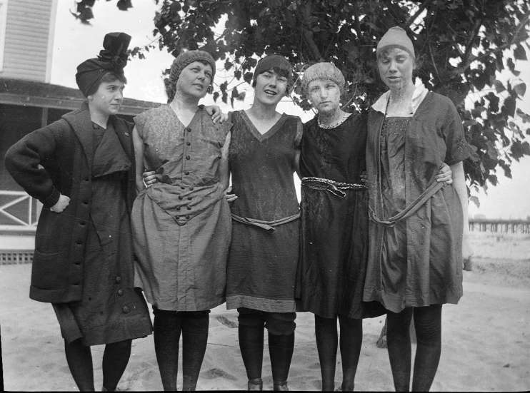 three women and one is wearing a hat with a bow in her hair