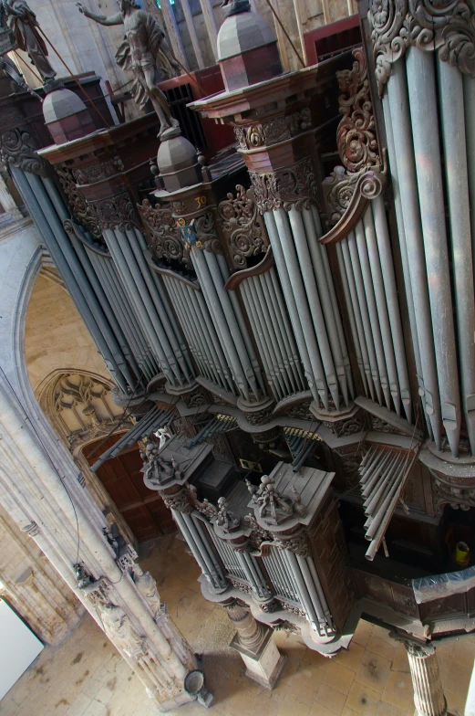 pipe organ in an old, worn church with ornate carvings