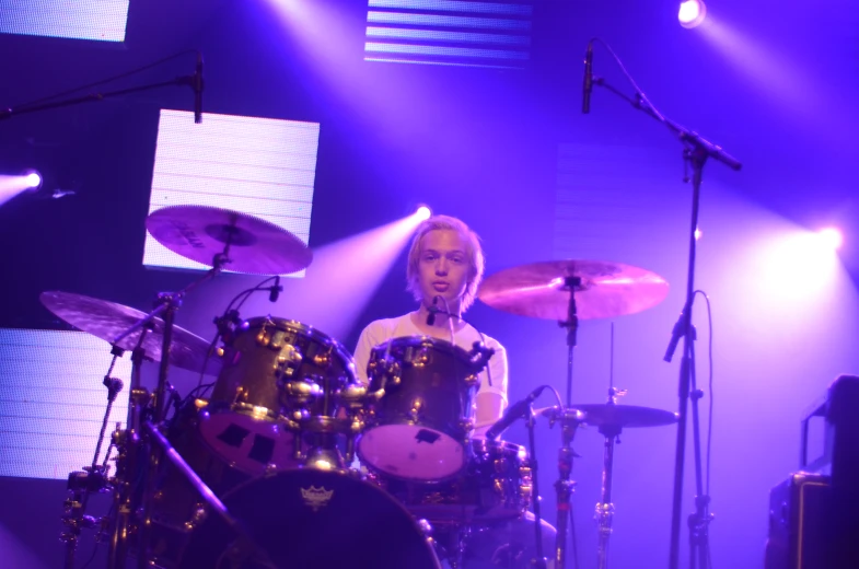 a woman playing drums on stage at a concert