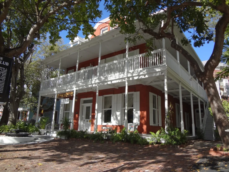 an orange and white house that is surrounded by trees